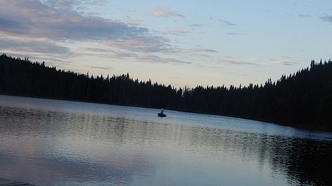 Un pêcheur sur le lac pendant que le soleil se lève